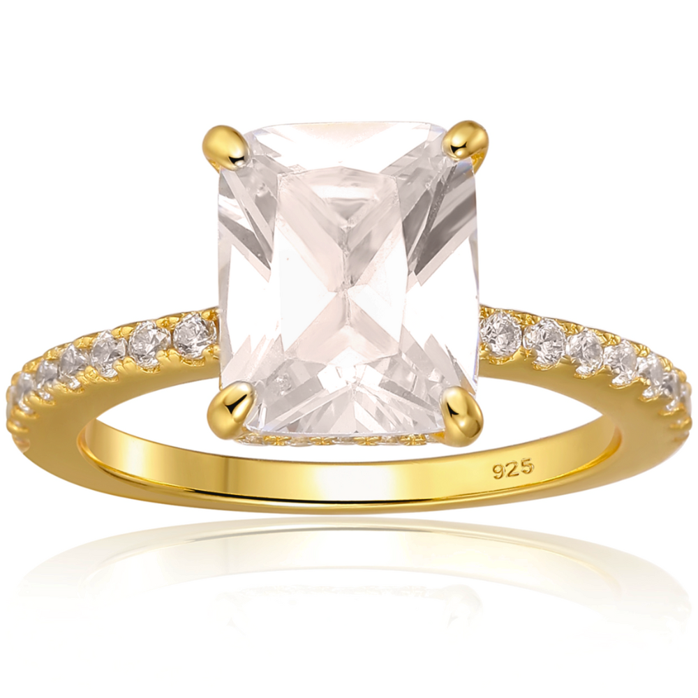 Features a 3-carat center emerald-cut stone with a hidden halo underneath the main stone
Triple A CZ stones in a sterling silver setting
14K gold plating
Set in a gorgeous 4 prong setting

Available in silver and in sizes 4 through 11