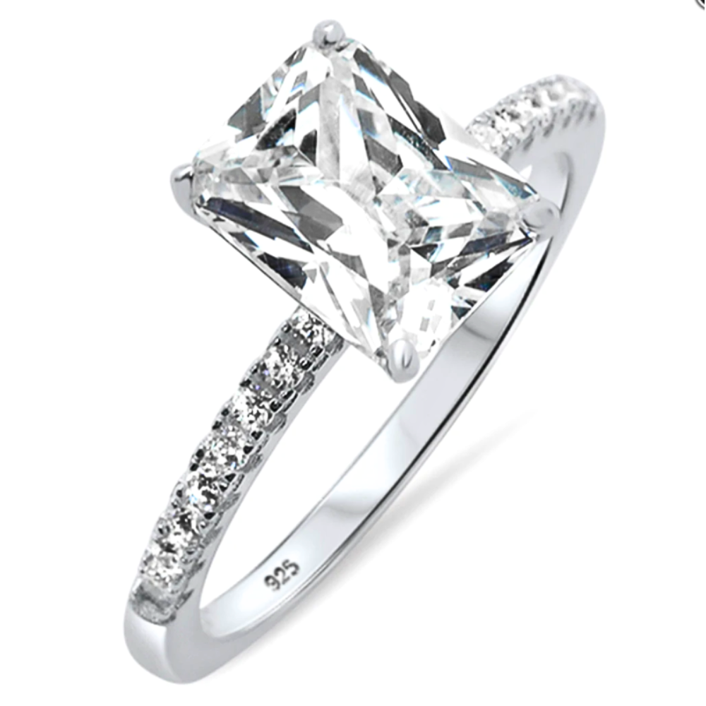 Features a 2-carat radiant-cut center stone
Set in a basket prong setting
Surrounded by a pavé style band in sterling silver and plated in Rhodium
Available in sizes 4 through 10